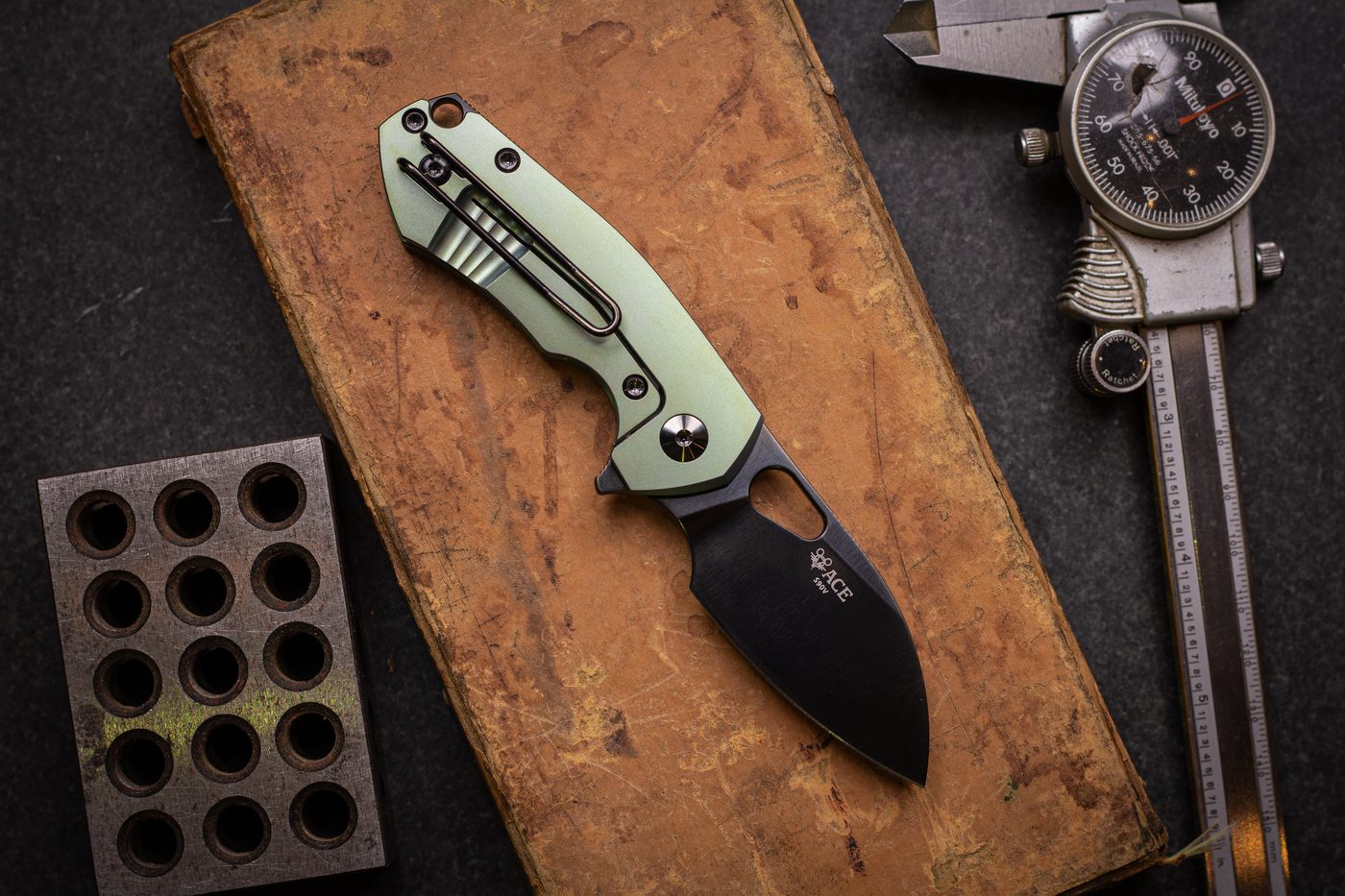Pocket knife on a clean desk beside a notebook