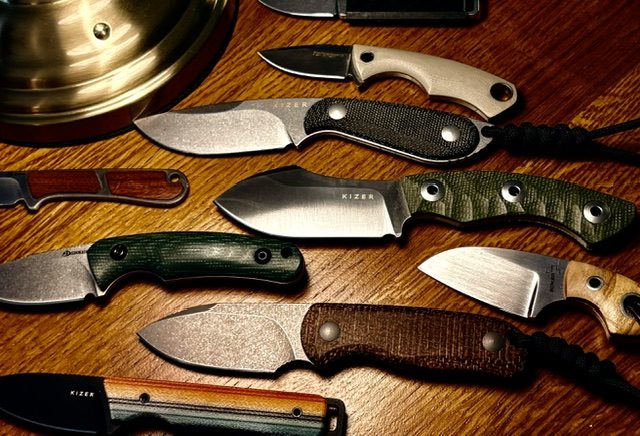 EDC fixed blade knives spread on a wooden table