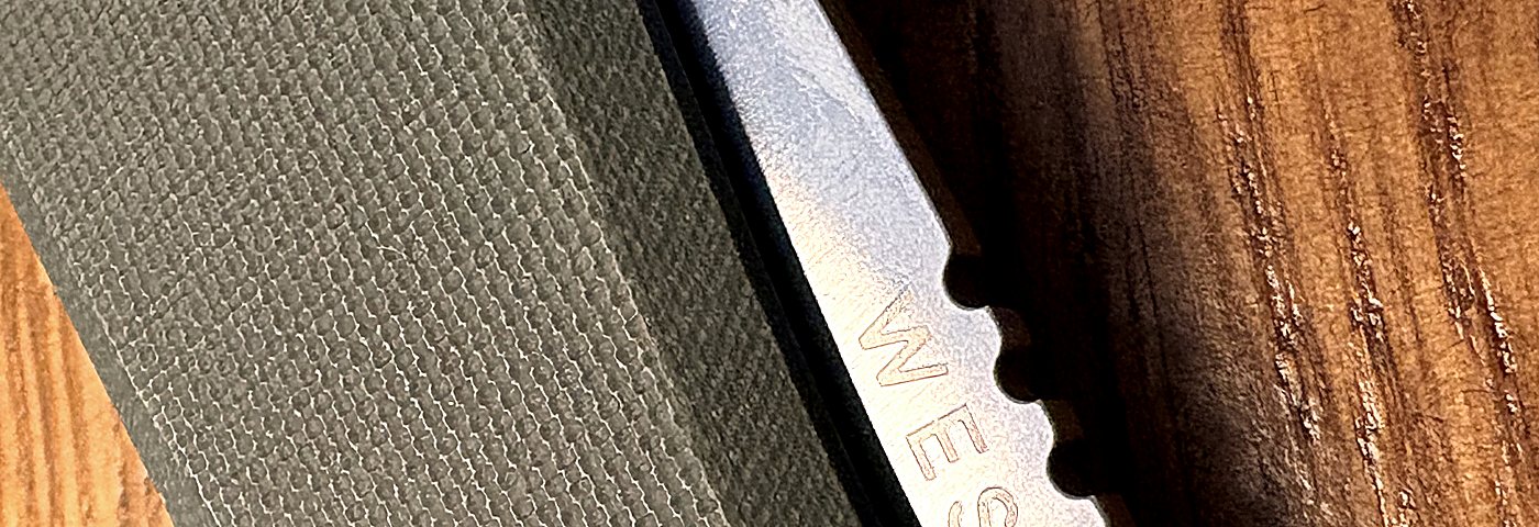 WESN knife handle and blade detail, worn wood surface
